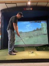 Golfer using the simulator