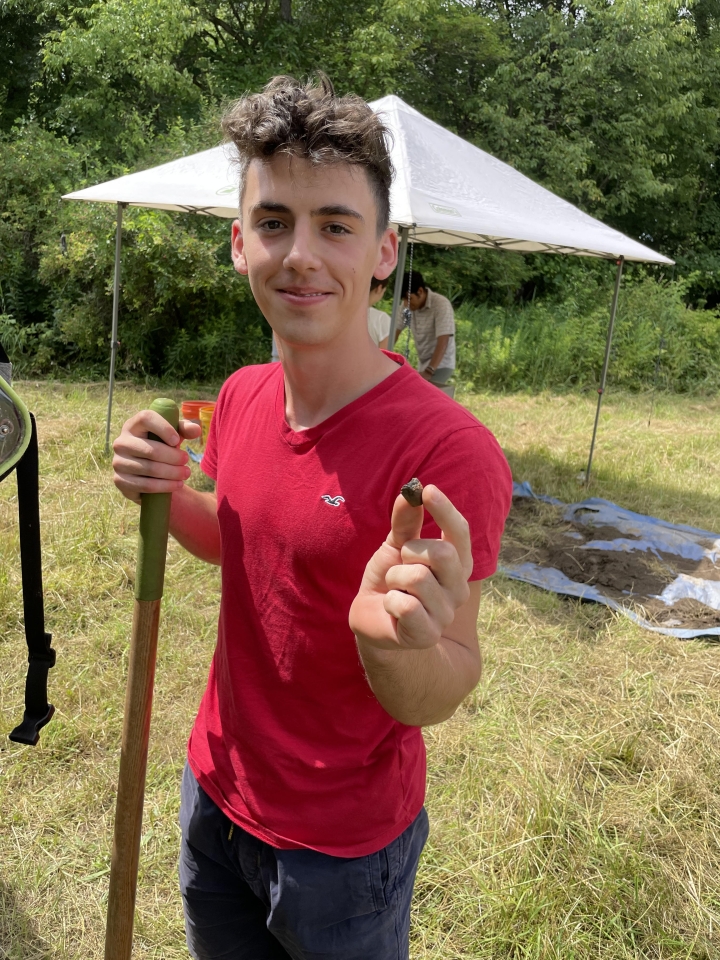 Volunteer holds 800 yr old ceramic pipe at Canticle Farms