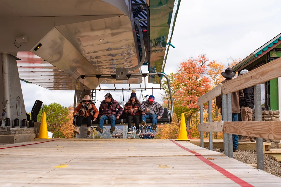 riders on a ski lift in fall