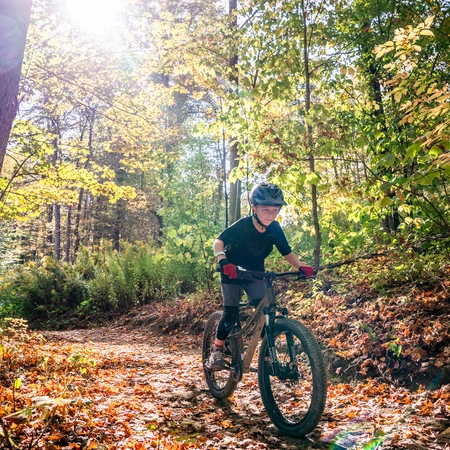 A kid mountain biking on HoliMont's Bike Park Trails