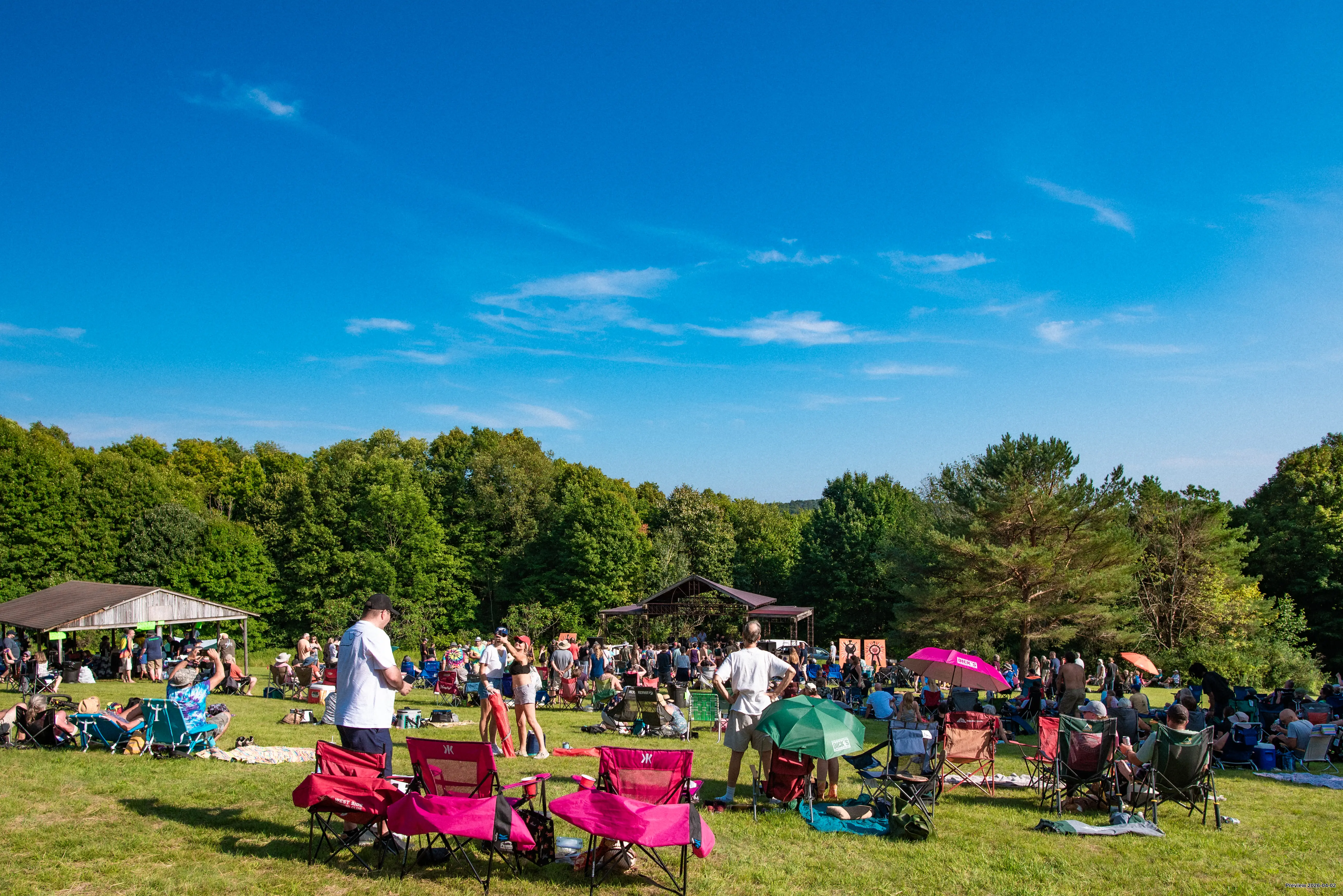 Summer Festival at Griffis, people in a field overlooking music pavilion