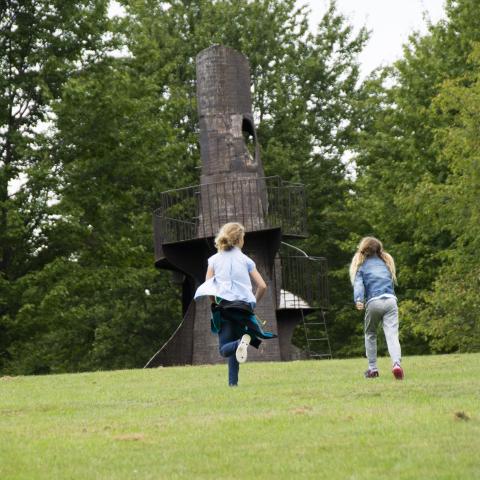 Kids running to tower sculpture