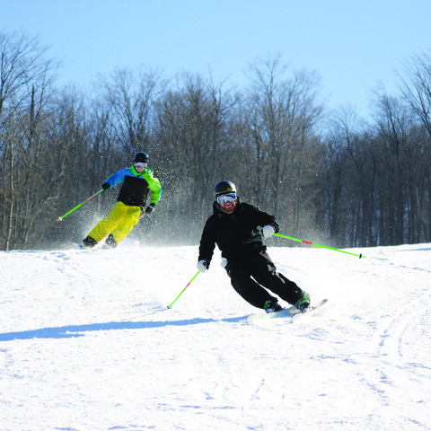 Skiers speeding downhill at HoliMont
