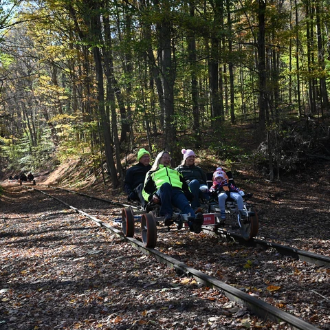 Family riding a rail bike in late autumn
