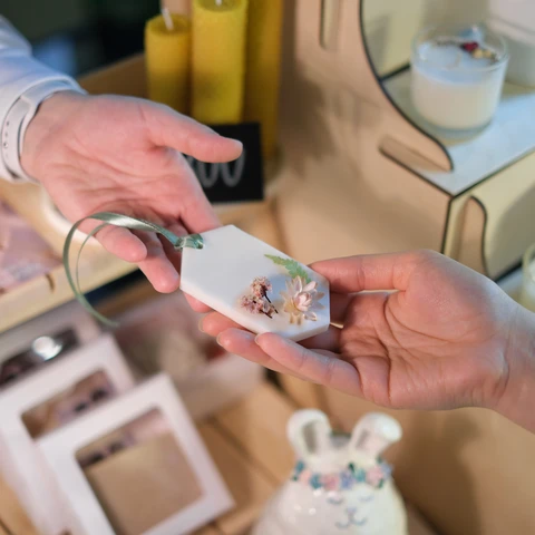 Vendor handing an item to buyer at a craft show