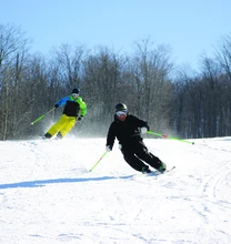 Skiers speeding downhill at HoliMont